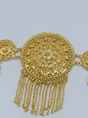 Macro close-up of the large central filigree medallion showing concentric floral cutwork, beaded border, and multi-strand chain tassel with ball tips