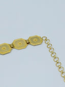 Detail of the extension chain closure end showing the last octagonal panels and round-link chain in warm gold-tone