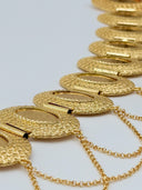 Side angle view of the waist belt showing the depth of the hinged oval medallions, bar hinge connections, and multi-strand swag chains in warm gold-tone