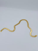 Full flat lay view of the gold-tone engraved coin disc waist belt showing the full length of linked discs and decorative clasp closure