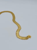 Angled view of the waist belt showing the decorative clasp end and repeating engraved coin discs with jump ring links along both edges