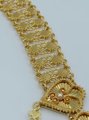 Extreme macro close-up of the wide clover-link open mesh chain body showing the interlocking loop texture and a single heart fan medallion with white bead center in warm gold-tone