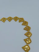 Angled view of the belt body showing the row of hinged filigree heart medallions with beaded borders, white bead centers, and the V-drape chain tassel fringe at the front