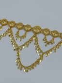 Close-up of the front showing repeating round open-lattice filigree medallions with raised floral centers and rope-twist borders, suspending cascading coin disc swag chains