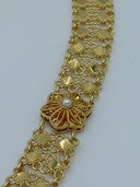 Close-up of the wide open-lattice diamond-link mesh chain body showing the interlocking diamond-shaped links and a single sunburst flower medallion with white bead center