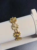 Gold floral bracelet on a white jewelry display