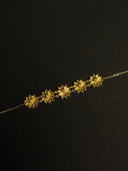 Gold floral necklace on a black background