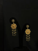Pair of gold-tone drop earrings with circular filigree stud top, openwork flower drop, and cascading dark faceted bead tassels