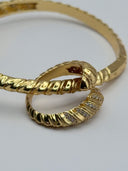 Detail shot of gold-tone Serpenti pavé bangle showing double-coil serpent head terminal and crystal-set scale segments