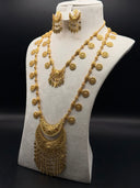 Gold-tone Hilal bridal jewelry set displayed on a white bust, featuring a long coin charm necklace with crescent filigree tassel pendant and matching chandelier earrings