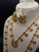 Detail view of the Hilal set showing the engraved round coin charms, barrel connectors on the chain, and the crescent chandelier earrings with filigree detailing and tassel drops
