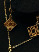 Detail view of the Cannage hook-drop earrings showing the diamond-oriented square lattice face and beaded border, alongside the pendant chain