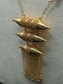 Close-up of the Fanous cascading pendant showing three graduated filigree lanterns with arabesque cutwork and pointed cone caps, finished with a multi-strand chain fringe and gold-tone ball tips