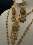 Close-up of the Rawdha chandelier earrings and necklace pendant showing the rectangular filigree top panel, round medallion centre, five tassel chains with teardrop drops, and hexagonal arabesque pendant face