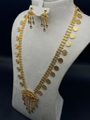 Full view of a 2-piece gold-tone jewelry set on a bust display, showing a wide ladder-link chain with coin charms, an eye-shaped pendant with tassel drop, and matching drop earrings