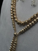 Close-up of the double-strand bead chain showing alternating ribbed and matte round beads with an engraved connector bead where the strands meet