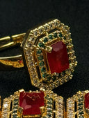 Close-up of the octagonal ring from the set, showing the deep red centre stone surrounded by a green zirconia inner halo and white zirconia outer halo in a gold-tone setting