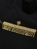Full set flat lay showing the wide gold-tone tassel choker with linked square panels and cascading multi-strand drops, alongside the matching ring, on a black background