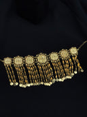 Gold-tone choker with a row of octagonal filigree medallions and cascading multi-strand tassel drops of leaf-shaped beads ending in flat coin discs, laid flat on a black background