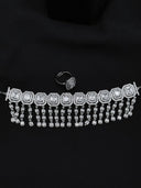Silver-tone choker with linked emerald-cut double halo panels and cascading square-cut stone tassel drops, displayed flat on a black background alongside the matching cocktail ring