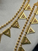 3-piece gold-tone triangle pendant jewelry set on a bust display — choker necklace, opera-length necklace, and drop earrings with coin disc charms