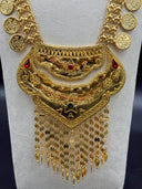 Close-up of the layered bib pendant showing zigzag lattice top tier, hammered middle tier with red stone star motif, floral-embossed lower tier, and cascading coin and torpedo tassel fringe