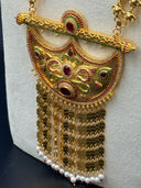 Detail shot of the chandelier earrings alongside the coin chain necklace, highlighting the gold bar tassels, white pearl drops, and red bead accents against the cream bust surface