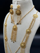 Side view of the necklace and earring set on a white bust showing the layered multi-strand ball-link chains, filigree medallion stations, and cascading bead tassel drops with coin disc finishes