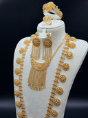 Three-quarter view of the bridal set on a white bust showing the layered coin chain side strands with round medallion discs, the double crescent pendant with chain tassel fringe, and the matching earrings
