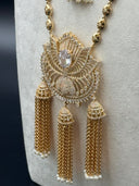 Macro close-up of the large lotus pendant showing the open petal silhouette with pave stone body, central oval stone, jhumka-style bell cap, and three dense chain tassels finished with white bead drops
