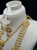 Close-up of the upper necklace section and earrings on a white bust showing the clover-link chain structure, a sunburst filigree medallion station, and the earring hook with round filigree body and teardrop drops