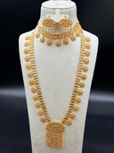 Close-up detail of the diamond-link clover chain necklace showing engraved round coin discs with floral center motifs and beaded border edges, suspended at intervals from the chain, with the oval filigree pendant partially visible at top left