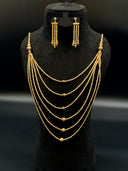 Full 2-piece jewelry set on a black velvet bust — 5-strand layered twisted bead necklace with tassel drops at the shoulders and matching 3-strand tassel drop earrings