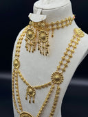 Three-quarter angle view of the full set on a bust, highlighting the layered necklace arrangement, choker, and earrings