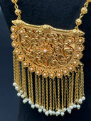 Close-up of the half-moon filigree pendant showing scrolling floral cutwork, flower rosette border, and white bead-tipped chain tassel fringe