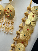 Front view of the necklace showing graduated coin discs, filigree ball spacers, and the large oval centerpiece pendant with tassel drops